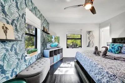 a bedroom with a large bed and a tv at Spanish 5 Bedroom Pool House Minutes to the Beach in Hollywood