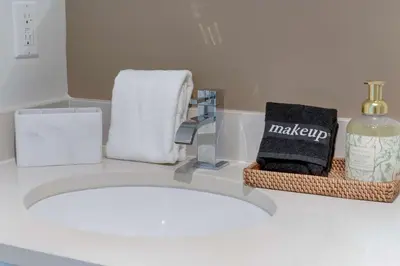 a bathroom with a sink with towels and a mirror at Midtown Miami Marvel- Heated Pool & Prime Location in Miami