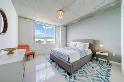 a bedroom with a bed and a table and a chair at Midtown Miami Marvel- Heated Pool & Prime Location in Miami