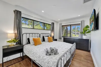 a bedroom with a large bed and two windows at Cute 3 Bedroom 2 Bathroom Pool Home in Hollywood