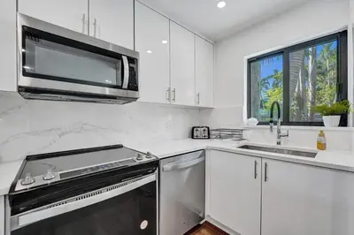a white kitchen with a stove and a microwave at Cute 3 Bedroom 2 Bathroom Pool Home in Hollywood