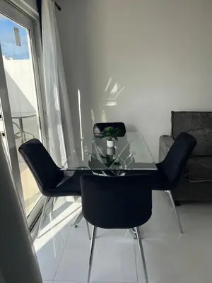 a glass dining table with chairs and a plant on it at The Azure Terrace Loft in Miami Beach