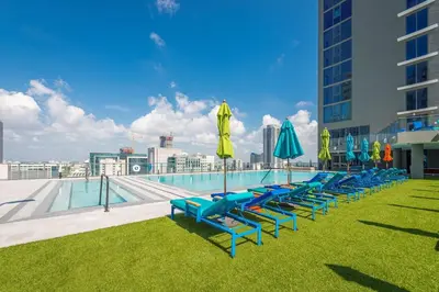 a row of lounge chairs with umbrellas and a pool at Amazing property in Miami