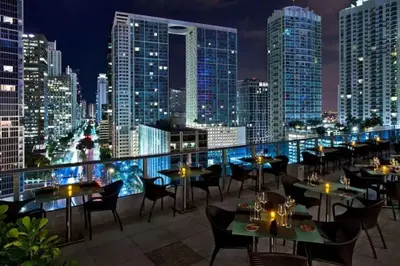 a restaurant with tables and chairs on the roof of a building at Newly Renovated 1BR Brickell Condo plus Parking in Miami