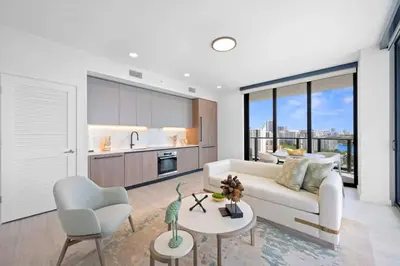 a living room with a white couch and a kitchen at NOK Classy 2BR in Miami Beach in Miami Beach