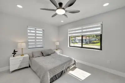 a white bedroom with a bed and a ceiling fan at NEW house in Miami Casa Calle 19 in Miami