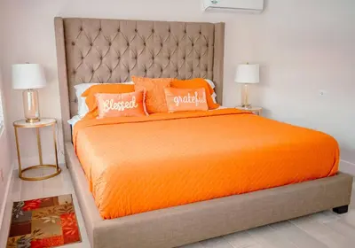an orange bed with two pillows on top of it at Bimini Bliss Waterfront Pool Retreat in Fort Lauderdale