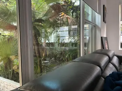 a leather couch in a room with a large window at Private House Beach in Miami Beach