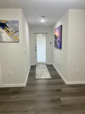 an empty hallway with white walls and wood floors at New 3BR in Central Miami Location for Family & Groups in Miami
