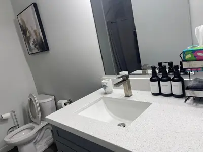 a bathroom with a sink and a toilet and a mirror at New 3BR in Central Miami Location for Family & Groups in Miami