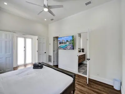 a white bedroom with a bed and a tv at Classic 5 Bedroom 4 Bathroom Pool Home in Hollywood