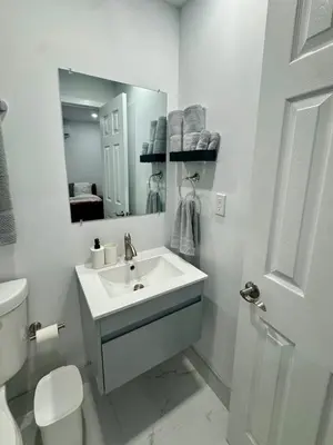 a white bathroom with a sink and a mirror at Elegant Miami South Stay! in Cutler Bay