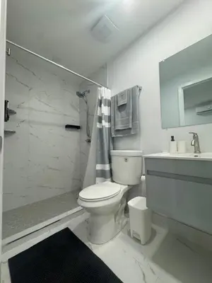 a white bathroom with a toilet and a shower at Elegant Miami South Stay! in Cutler Bay