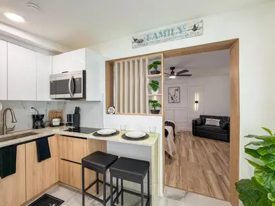 a kitchen and living room with a counter and stools at King Comfort Suite Kitchen Wi-Fi Parking in Pembroke Pines