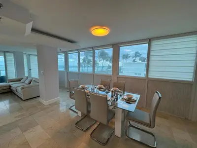 a dining room with a table and chairs and a couch at Beachfront two story apartment in Miami Beach