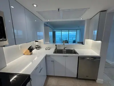 a kitchen with white counters and a sink at Beachfront two story apartment in Miami Beach