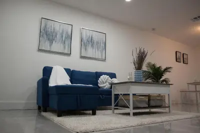 a blue couch in a living room with a table at 20 OFF BLUE WAVE 10min Beach and Airport in Fort Lauderdale