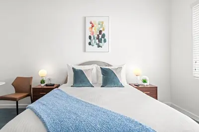 a bedroom with a large bed with blue pillows at Bluebird Suites at The Apex Miami in Miami Beach