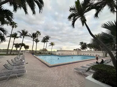 a swimming pool with lounge chairs and palm trees at Miami Beach-Front with Amazing Pool in Miami Beach