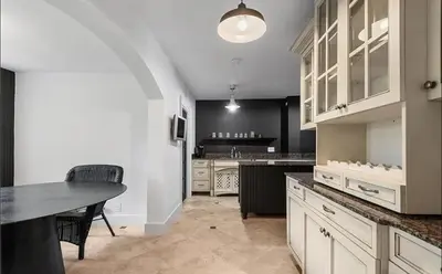 a kitchen with white cabinets and a table with chairs at Historic Sailboat Bend Home 5 Min to Las Olas 4 miles to the Beach in Fort Lauderdale