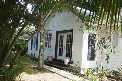 a white house with palm trees in front of it at Newly Renovated Home- Sailboat Bend - Walk to Las Olas - 4 Miles to Beach in Fort Lauderdale