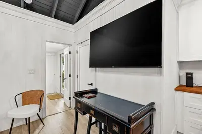 a large flat screen tv on a wall with a desk at Newly Renovated Home- Sailboat Bend - Walk to Las Olas - 4 Miles to Beach in Fort Lauderdale