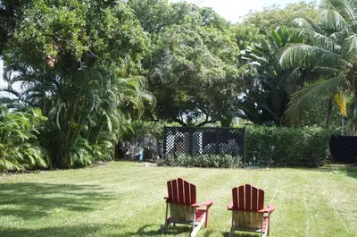 two chairs sitting in the grass in a yard at Newly Renovated Home- Sailboat Bend - Walk to Las Olas - 4 Miles to Beach in Fort Lauderdale