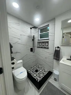 a bathroom with a toilet and a black and white floor at Newly Renovated Home- Sailboat Bend - Walk to Las Olas - 4 Miles to Beach in Fort Lauderdale