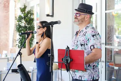 a man and a woman singing into microphones at Cardozo Hotel in Miami Beach