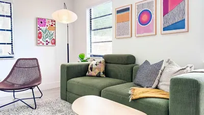 a living room with a green couch and a chair at Cloud Nine - Wilton Drive Jacuzzi Backyard in Fort Lauderdale