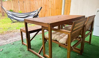 a wooden table and two chairs with a table and a bench at The Hideaway - Wilton Manors in Fort Lauderdale