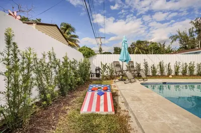 a pool with an american flag table next to a house at 4 BR home with private pool in Fort Lauderdale