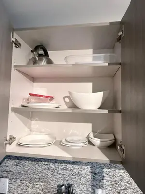 a kitchen with white plates and bowls on shelves at Stylish Urban 5350 Park Doral in Miami