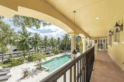 an indoor balcony with a pool and palm trees at Serene 7000 SF Gated Luxury Waterfront Home in Fort Lauderdale