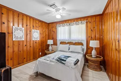 a bedroom with wooden walls and a bed with two lamps at Brazilian Style Getaway 2 Minutes to Beach in Hollywood