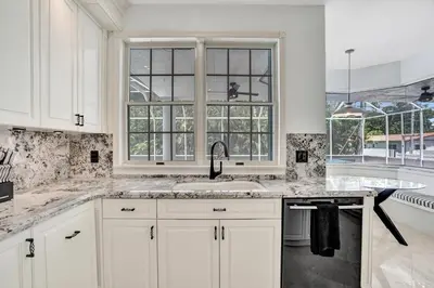 a white kitchen with a sink and a window at 6BR Elegant Hollywood Lakes Mansion with Private Pool & Spa in Hollywood