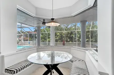a dining room with a glass table and benches at 6BR Elegant Hollywood Lakes Mansion with Private Pool & Spa in Hollywood