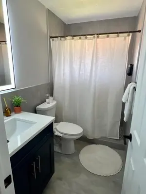 a bathroom with a white toilet and a sink at 20 OFF Golden Hour BBQ 10 MIN Beach Airport FL in Fort Lauderdale
