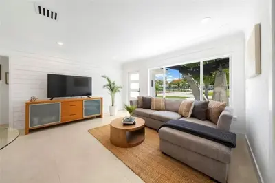 a living room with a couch and a flat screen tv at 4BR Lakefront Heated Pool -Jacuzzi -Basket -Sauna in Fort Lauderdale