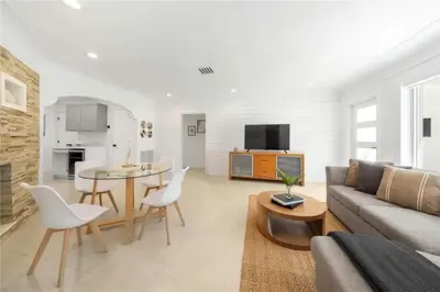 a living room with a couch and a table at 4BR Lakefront Heated Pool -Jacuzzi -Basket -Sauna in Fort Lauderdale
