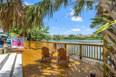 a deck with chairs and a view of the water at 4BR Lakefront Heated Pool -Jacuzzi -Basket -Sauna in Fort Lauderdale