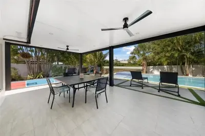 a dining room with a table and chairs and a pool at 4BR Lakefront Heated Pool -Jacuzzi -Basket -Sauna in Fort Lauderdale