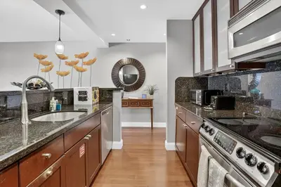 a large kitchen with wooden cabinets and a sink at Beach Haven Condo for 2 in Fort Lauderdale