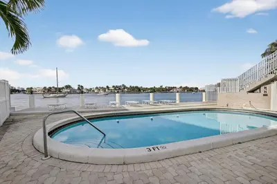 a swimming pool in front of a body of water at Beach Haven Condo for 2 in Fort Lauderdale