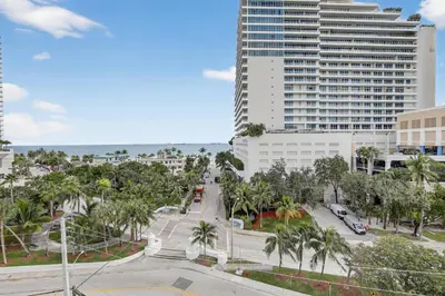 a city street with palm trees and a tall building at Beach Haven Condo for 2 in Fort Lauderdale