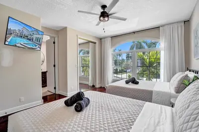 a bedroom with two beds and a flat screen tv at 6BR Elegant Hollywood Lakes Mansion with Pool & Spa home in Hollywood