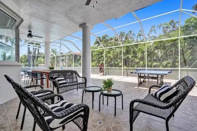 a conservatory with chairs and tables and windows at 6BR Elegant Hollywood Lakes Mansion with Pool & Spa home in Hollywood