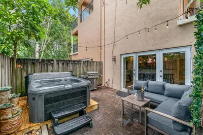 a patio with a couch and a grill at Salty Fox 5BD Oasis w Spa, Beach & Downtown in Fort Lauderdale