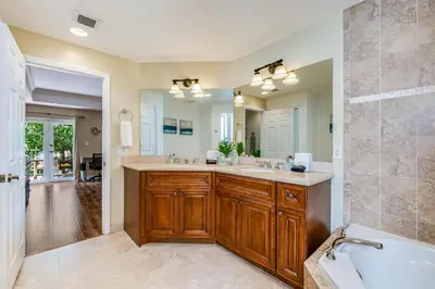 a bathroom with a sink and a tub and a mirror at Salty Fox 5BD Oasis w Spa, Beach & Downtown in Fort Lauderdale