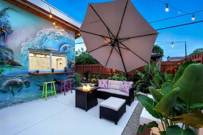 a patio with a couch and an umbrella at Private Retreat with Yard Near Hard Rock Stadium in Miramar